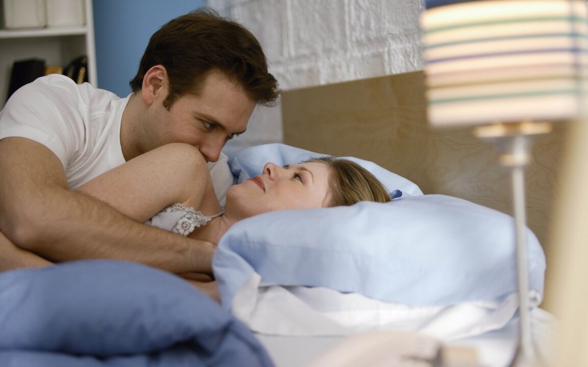 woman in bed with a man with an enlarged penis